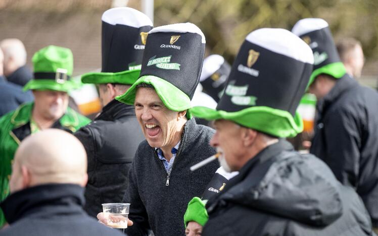 A group of race goers in St Patricks Day hats enjoying their day.