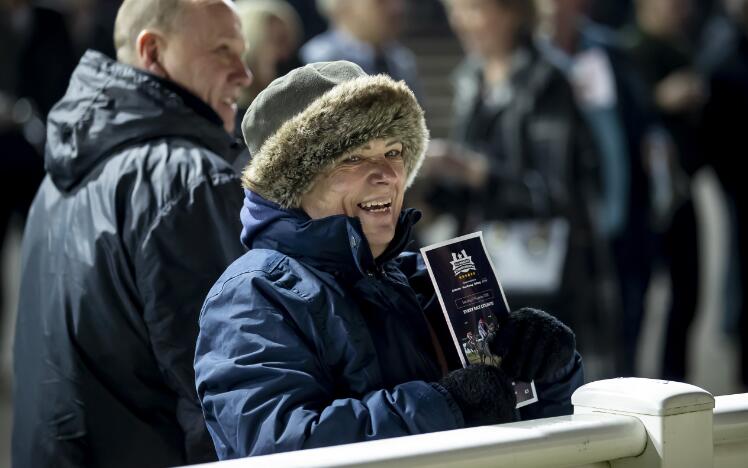 A race goer dressed for the cold smiles at the trackside at Wolverhampton Racecourse